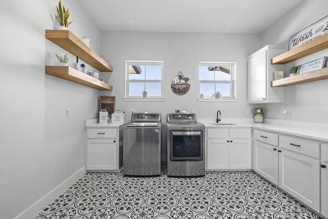 1215 Ropers Alley Rd, Belton, TX 76513 - laundry area with washer and clothes dryer, a sink, cabinet space, light tile patterned flooring, and baseboards