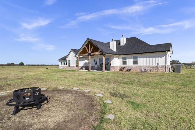 1215 Ropers Alley Rd, Belton, TX 76513 - back of property featuring brick siding, a lawn, board and batten siding, and a chimney