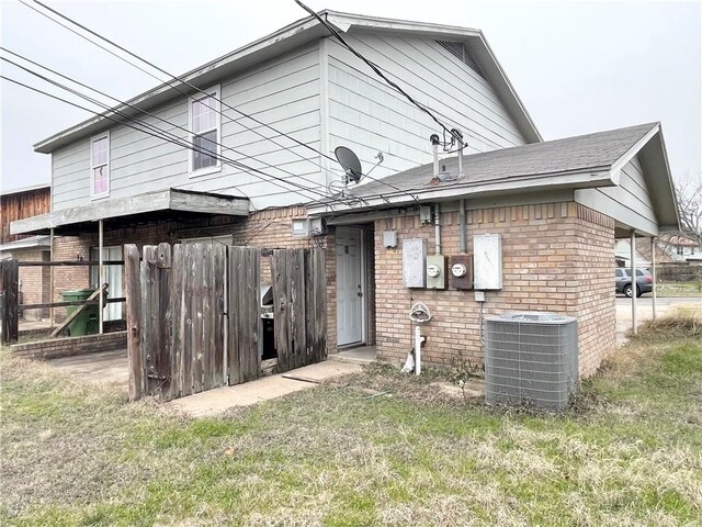 5505 Tennyson Dr, Waco, TX 76710 - rear view of house with cooling unit, brick siding, and a yard