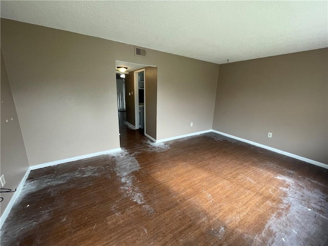 5505 Tennyson Dr, Waco, TX 76710 - empty room with visible vents, baseboards, a textured ceiling, and wood finished floors