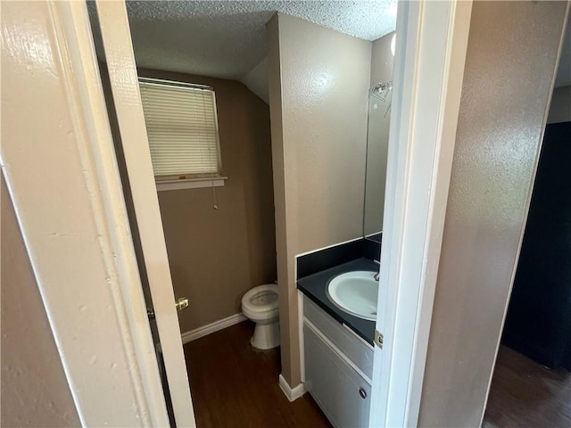 5505 Tennyson Dr, Waco, TX 76710 - bathroom with vanity, wood finished floors, baseboards, a textured ceiling, and toilet