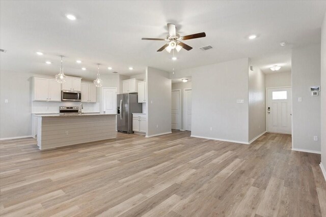 unfurnished living room with light wood-style flooring, baseboards, a ceiling fan, and recessed lighting