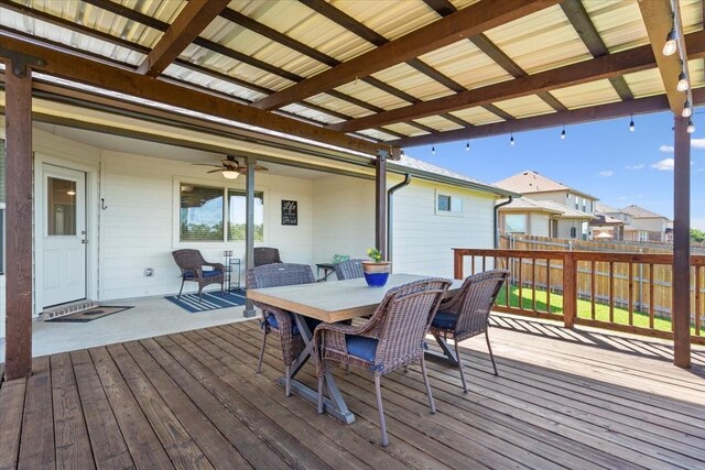 wooden terrace featuring a ceiling fan, outdoor dining area, and fence