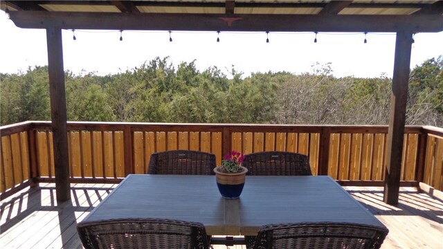 deck featuring a wooded view and outdoor dining area