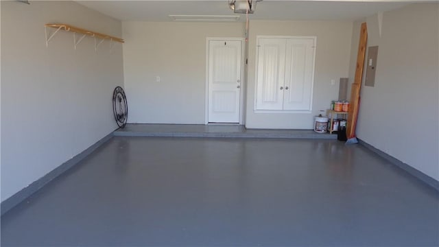 garage with baseboards, a garage door opener, and electric panel