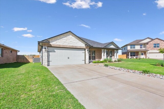 single story home featuring stone siding, a garage, fence, a front lawn, and driveway