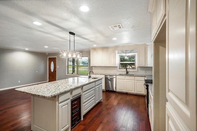 433 Sharron Dr, Woodway, TX 76712 - kitchen with visible vents, a center island with sink, a sink, tasteful backsplash, and stainless steel dishwasher