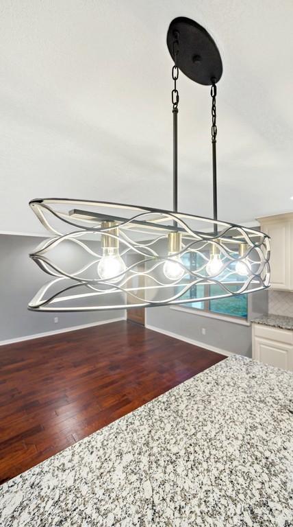 433 Sharron Dr, Woodway, TX 76712 - details with an inviting chandelier, wood finished floors, and baseboards