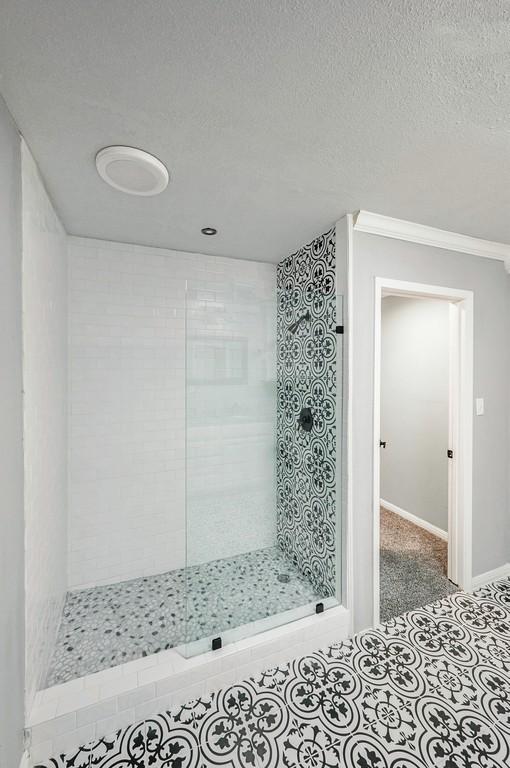 433 Sharron Dr, Woodway, TX 76712 - full bath with tile patterned flooring, a walk in shower, a textured ceiling, and baseboards