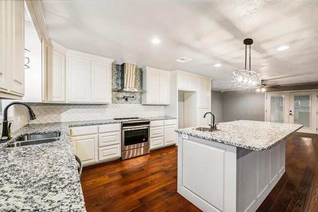 433 Sharron Dr, Woodway, TX 76712 - kitchen with a sink, stainless steel electric range oven, an island with sink, and wall chimney exhaust hood
