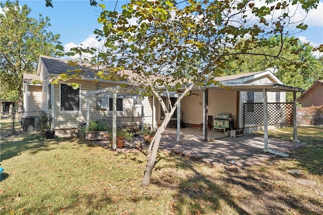 back of house with a carport, a yard, and fence