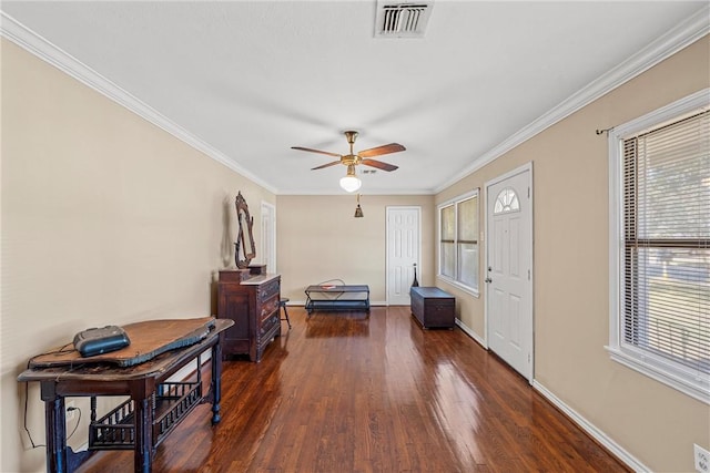 foyer featuring visible vents, dark wood-type flooring, baseboards, ceiling fan, and ornamental molding