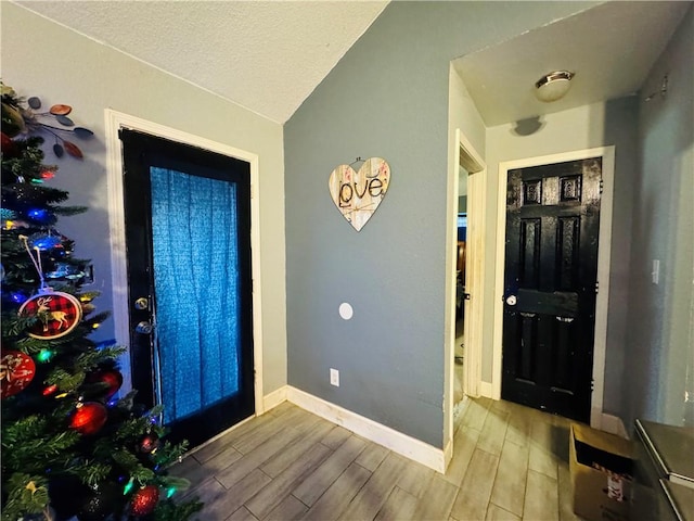 5703 Mandalay Dr, Killeen, TX 76549 - entrance foyer featuring a textured ceiling, lofted ceiling, baseboards, and wood tiled floor