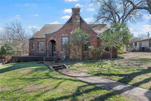 3100 Austin Ave, Waco, TX 76710 - english style home with a chimney, a front lawn, and brick siding