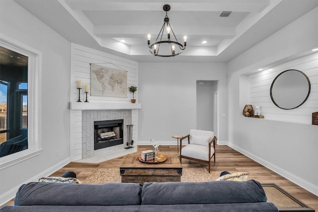 living area featuring a tiled fireplace, wood finished floors, and baseboards