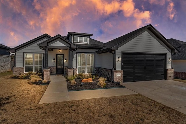 view of front of property featuring a garage, brick siding, and driveway