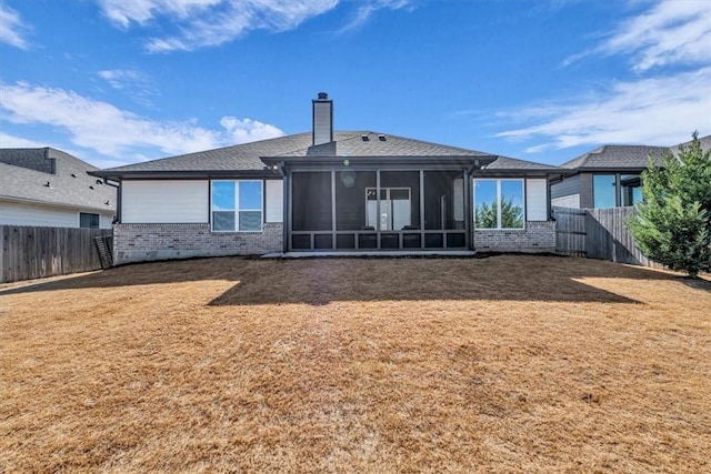 back of property featuring a lawn, a chimney, and a fenced backyard