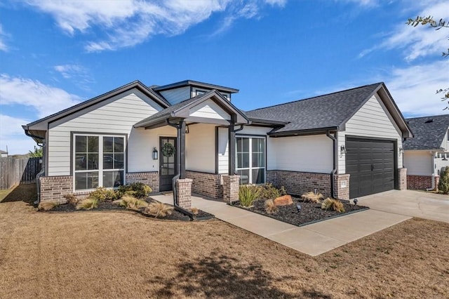 view of front of home with fence, a shingled roof, concrete driveway, a garage, and brick siding