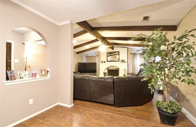 332 Crescent Dr, Hewitt, TX 76643 - living room with wood finished floors, a brick fireplace, arched walkways, baseboards, and ceiling fan