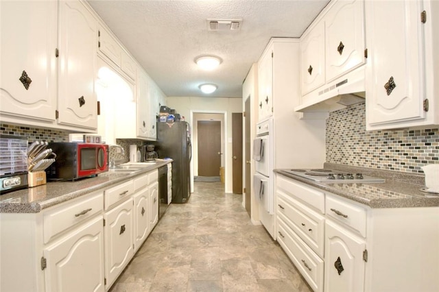 332 Crescent Dr, Hewitt, TX 76643 - kitchen with under cabinet range hood, electric cooktop, a textured ceiling, a sink, and decorative backsplash