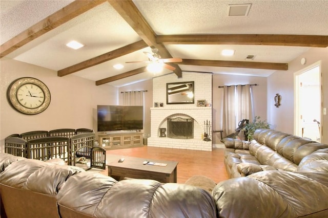332 Crescent Dr, Hewitt, TX 76643 - living room with a ceiling fan, wood finished floors, a textured ceiling, and a brick fireplace