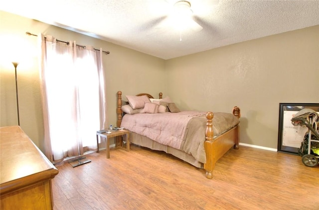332 Crescent Dr, Hewitt, TX 76643 - bedroom featuring light wood finished floors, multiple windows, ceiling fan, and a textured ceiling