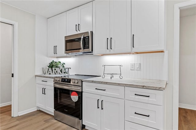 4209 Chestnut Rd, Temple, TX 76502 - kitchen featuring white cabinets, light stone counters, light wood-style floors, and appliances with stainless steel finishes