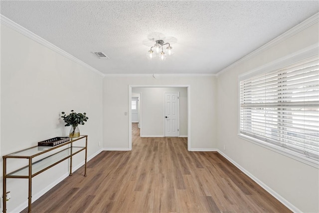 4209 Chestnut Rd, Temple, TX 76502 - empty room with wood finished floors, baseboards, an inviting chandelier, a textured ceiling, and crown molding