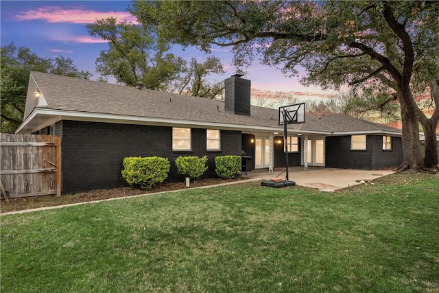 4209 Chestnut Rd, Temple, TX 76502 - rear view of property featuring brick siding, fence, a lawn, a chimney, and a patio area