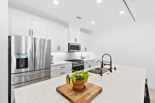 851 Cavitt Ct, Prosper, TX 75078 - kitchen with appliances with stainless steel finishes, a sink, decorative backsplash, white cabinets, and recessed lighting