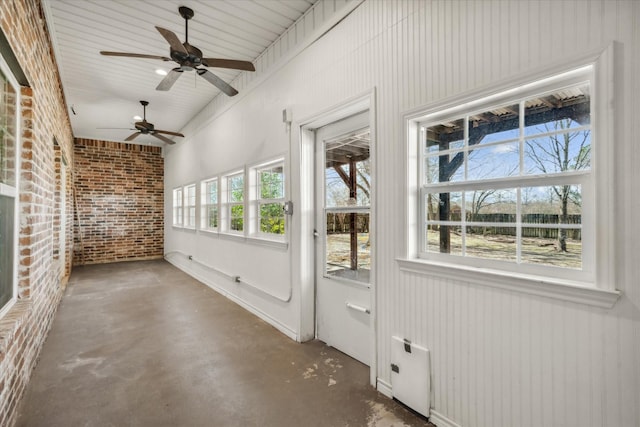 unfurnished sunroom featuring a ceiling fan