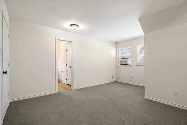 unfurnished bedroom with connected bathroom, baseboards, carpet floors, and cooling unit