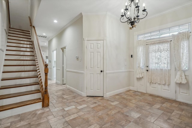 foyer entrance with visible vents, an inviting chandelier, stone tile flooring, and ornamental molding
