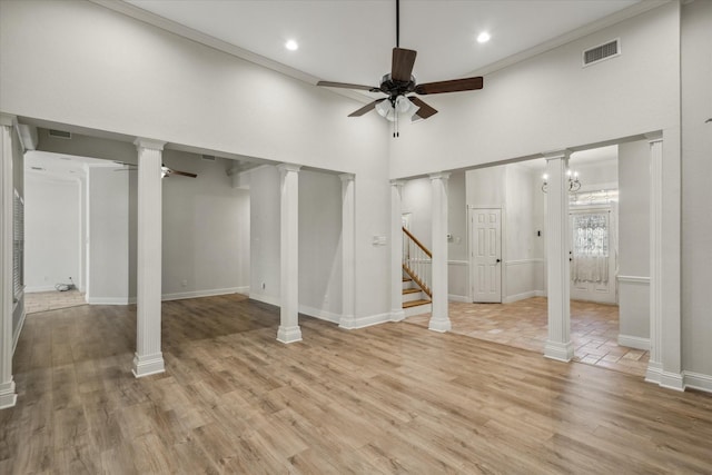 basement with crown molding, light wood-style flooring, visible vents, and ceiling fan