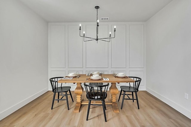 707 S 9th St, Waco, TX 76706 - dining space featuring a notable chandelier, light wood-type flooring, a decorative wall, and visible vents