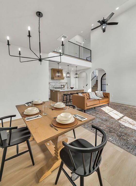 707 S 9th St, Waco, TX 76706 - dining area with visible vents, light wood-style flooring, a ceiling fan, arched walkways, and a towering ceiling
