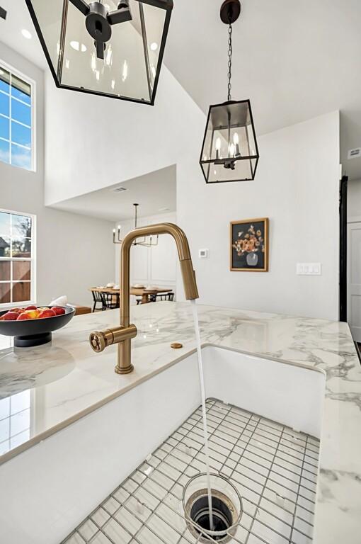 707 S 9th St, Waco, TX 76706 - room details featuring hanging light fixtures, an inviting chandelier, and light stone countertops