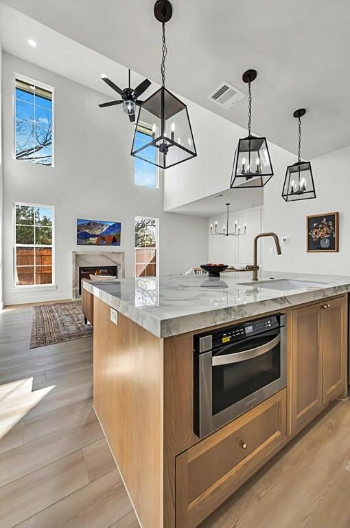 707 S 9th St, Waco, TX 76706 - kitchen with visible vents, oven, open floor plan, light wood-style floors, and a sink