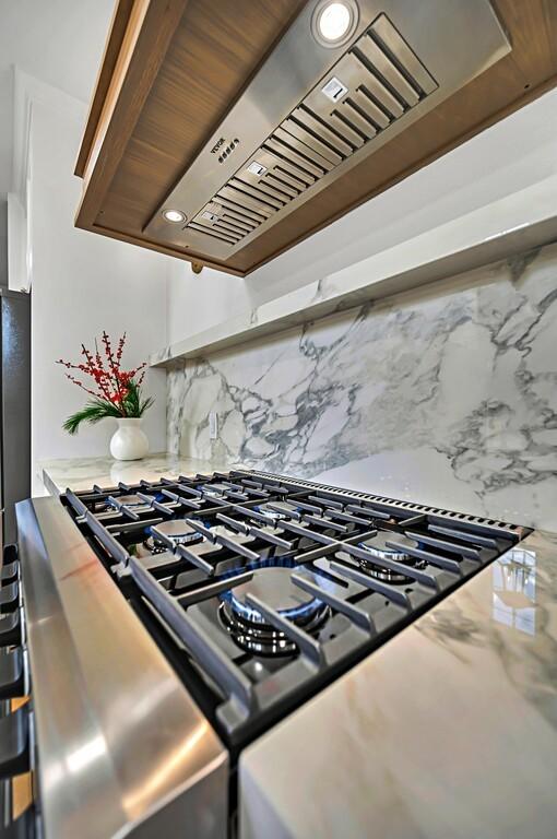 707 S 9th St, Waco, TX 76706 - room details featuring gas stove, backsplash, and custom exhaust hood
