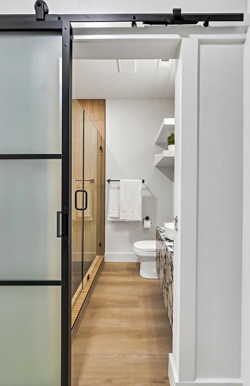 707 S 9th St, Waco, TX 76706 - full bathroom with a shower stall, toilet, vanity, and wood finished floors