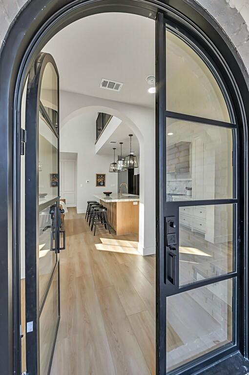 707 S 9th St, Waco, TX 76706 - entryway with light wood-type flooring, arched walkways, and visible vents