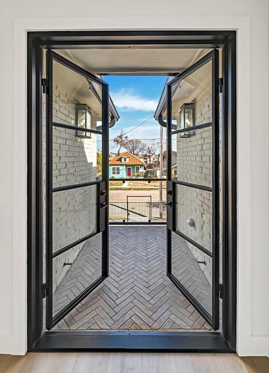707 S 9th St, Waco, TX 76706 - doorway featuring wood finished floors and brick wall