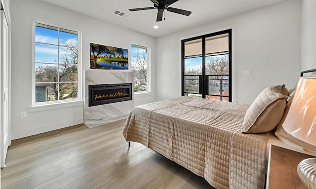 707 S 9th St, Waco, TX 76706 - bedroom featuring a glass covered fireplace, visible vents, multiple windows, and light wood-style flooring