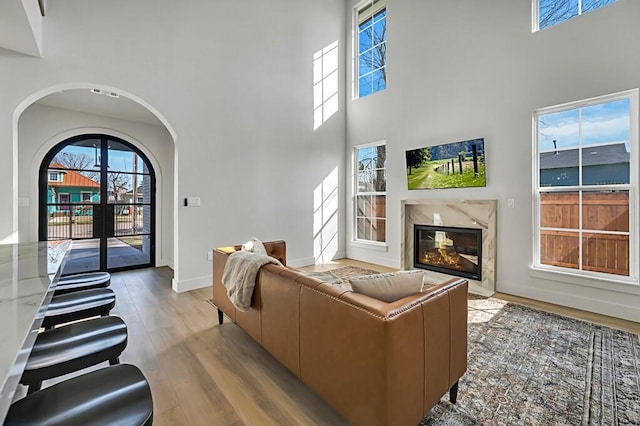 707 S 9th St, Waco, TX 76706 - living room with arched walkways, a healthy amount of sunlight, a high end fireplace, and wood finished floors