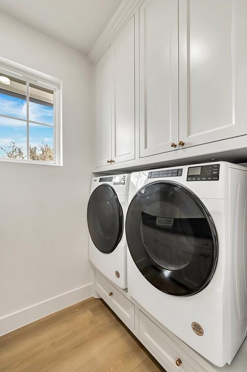 707 S 9th St, Waco, TX 76706 - washroom featuring cabinet space, washing machine and dryer, light wood finished floors, and baseboards