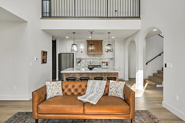 707 S 9th St, Waco, TX 76706 - living room featuring stairway, baseboards, arched walkways, and light wood finished floors
