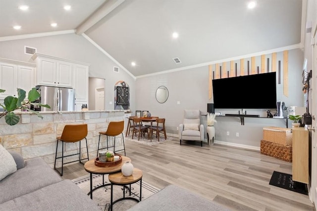 living area with light wood-style floors, visible vents, baseboards, and beam ceiling