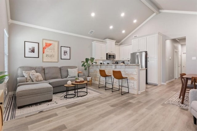 living room featuring high vaulted ceiling, crown molding, light wood-type flooring, beam ceiling, and visible vents
