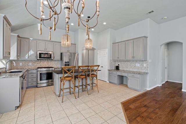 8664 Glenburne Dr, Fort Worth, TX 76131 - kitchen with visible vents, arched walkways, a sink, appliances with stainless steel finishes, and gray cabinetry