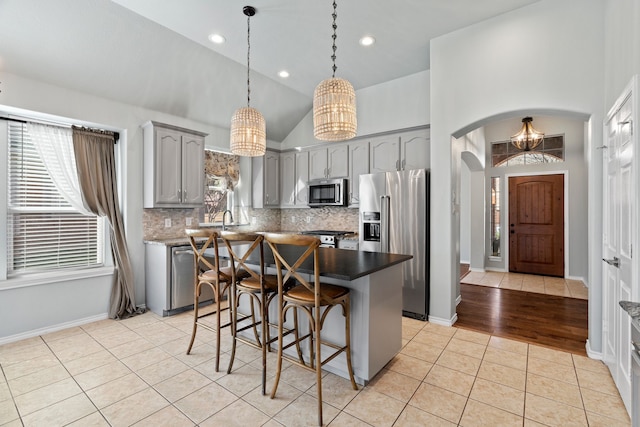 8664 Glenburne Dr, Fort Worth, TX 76131 - kitchen with appliances with stainless steel finishes, arched walkways, a chandelier, gray cabinets, and light tile patterned floors